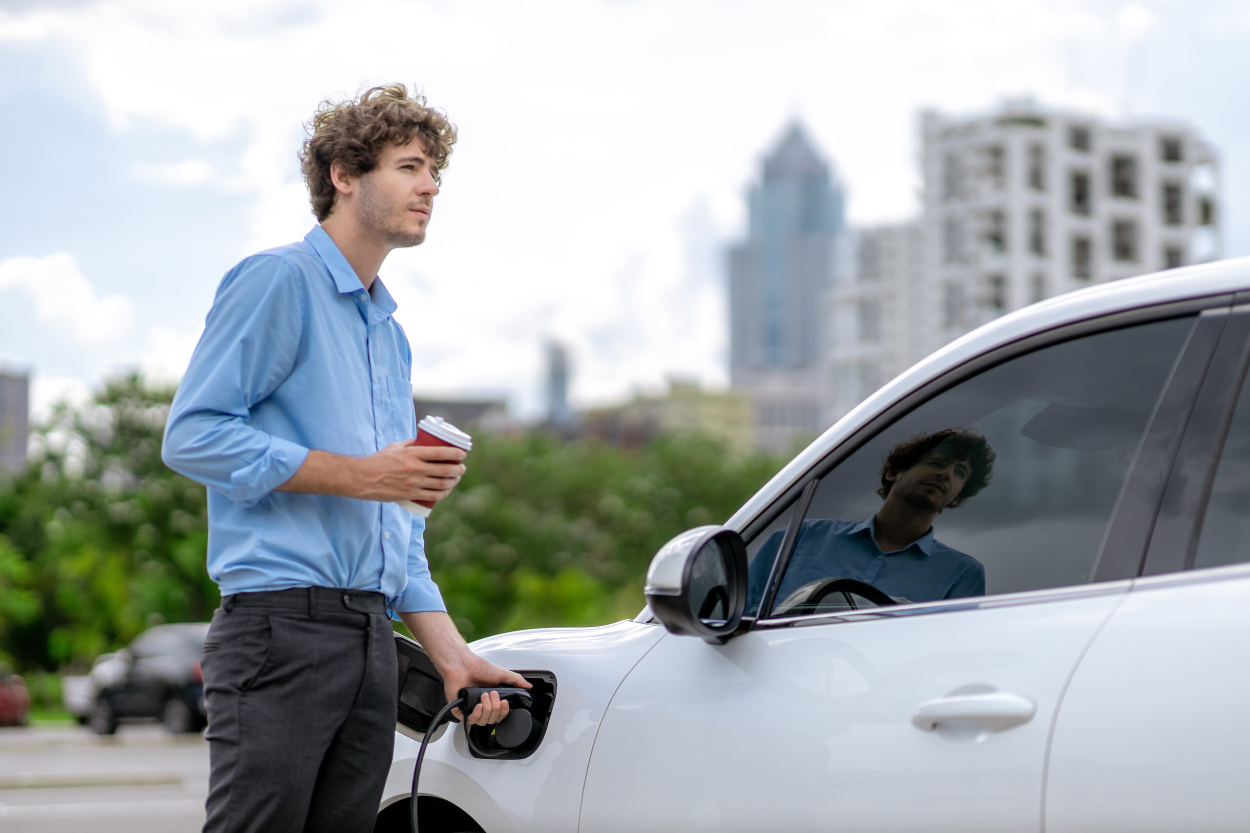 Progressive concept of EV car at charging station with blur man background