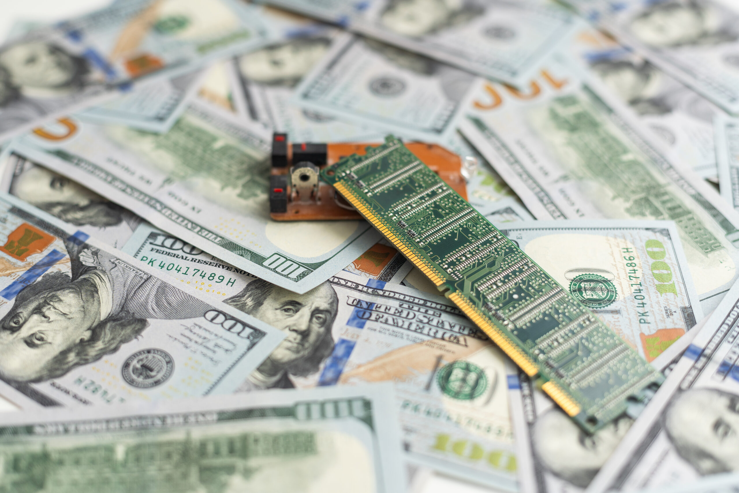 Semiconductor chips shortage and high price. Pile of computer chips and spreadof US dollars. Concept for crisis in the industry in the United States.